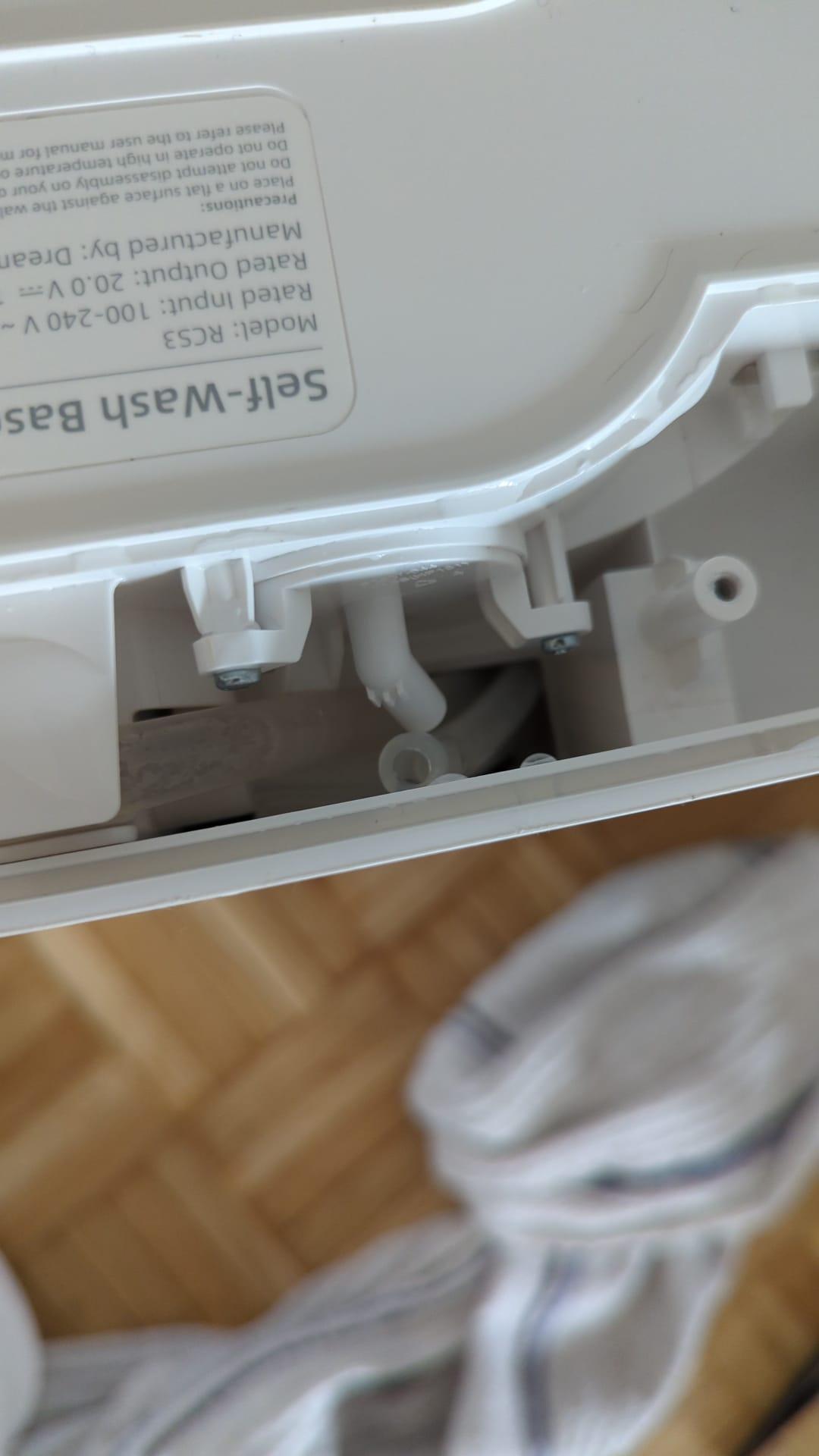Close-up of the robot's disassembled base with a tube being disconnected