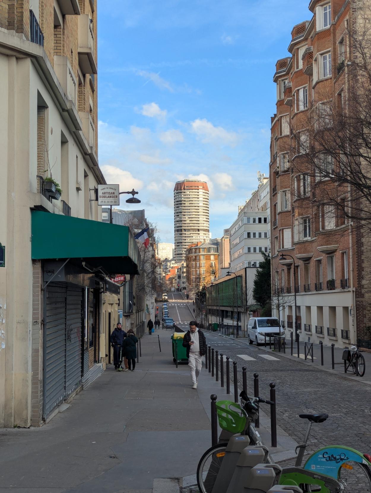A street, with a tower in the background. The road and lightning naturally draw the eye to the tower.
